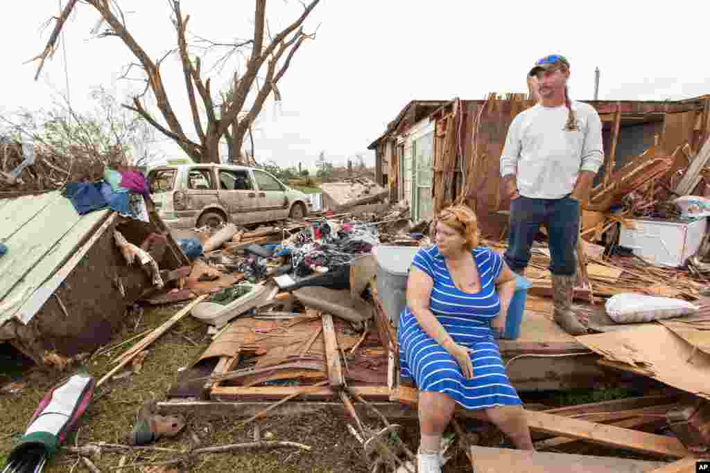 Raella Faulkner, at left, and Bobby McElroy survey what's left of their home, April 28, 2014, after a tornado struck the town of Vilonia, Arkansas late Sunday. 