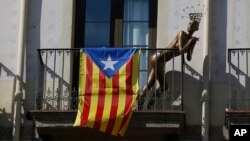 A mannequin stands next to a ''estelada'' or Catalonia independence flag, on a balcony, in Barcelona, Spain, Oct. 23, 2017.