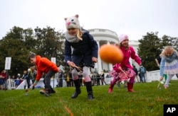 FILE - Julia Stimson, 8, from Alexandria, Va., and other children participate in the annual White House Easter Egg Roll on the South Lawn of the White House in Washington, Monday, April 2, 2018. (AP Photo/Pablo Martinez Monsivais)