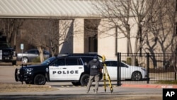An FBI agent processes the scene in front of the Congregation Beth Israel synagogue, Jan. 16, 2022, in Colleyville, Texas, where a man held hostages for more than 10 hours Saturday. 
