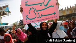 Sudanese protesters hold banners as they march outside the Defence Ministry compound in Khartoum, Sudan, April 29, 2019. (REUTERS/Umit Bektas)