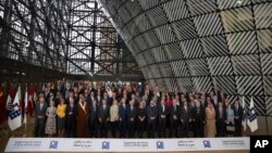 Officials pose for a group photo during a Syria donors conference at the European Council headquarters in Brussels, March 14, 2019.