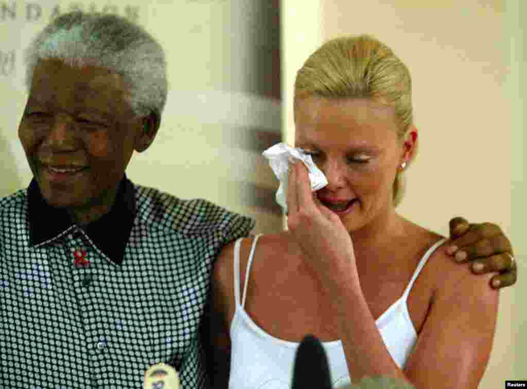 지난 2004년 3월 넬슨 만델라 전 남아공 대통령이 자신의 재단을 찾은 남아공 출신 여배우 샤를리즈 테론을 위로하고 있다. 