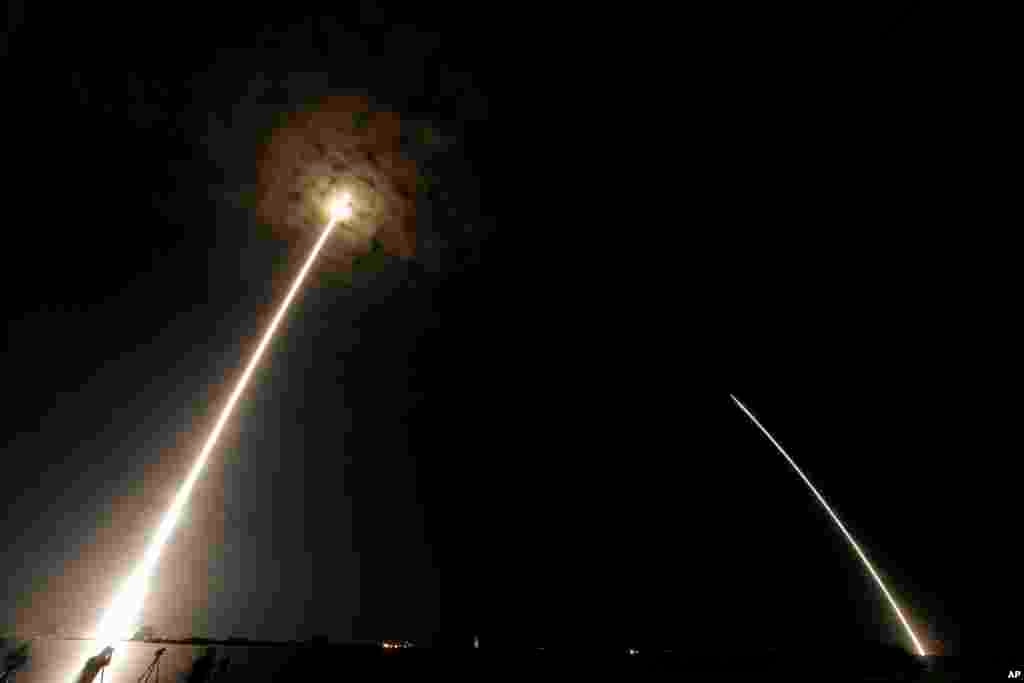 During a time exposure the Falcon 9 SpaceX rocket is seen, left, as it lifts off from launch complex 40 at the Cape Canaveral Air Force Station in Cape Canaveral, Florida.