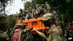 FILE - M23 rebels sit in a vehicle as they withdraw from the eastern Congo town of Goma, Dec. 2012.