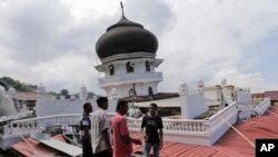 Men inspect a collapsed mosque after an earthquake in Pidie Jaya, Aceh province, Indonesia, Dec. 7, 2016. A strong undersea earthquake rocked Indonesia's Aceh province early Wednesday, killing a number of people and causing dozens of buildings to collapse.