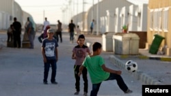 Syrian refugee children play with a soccer ball at the Mrajeeb Al Fhood refugee camp in Zarqa, Jordan, July 1, 2014.