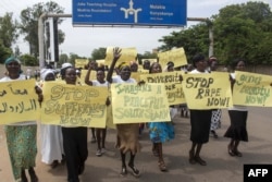 FILE - Women march carrying placards with messages demanding peace and their rights, on the streets of South Sudan's capital, Juba, July 13, 2018.