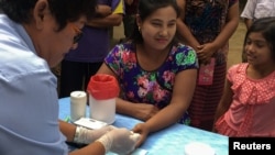 A public health worker takes a blood sample from a woman to be tested for malaria in Bo Rai district, Trat province, Thailand, Nov. 2017. (File Photo)