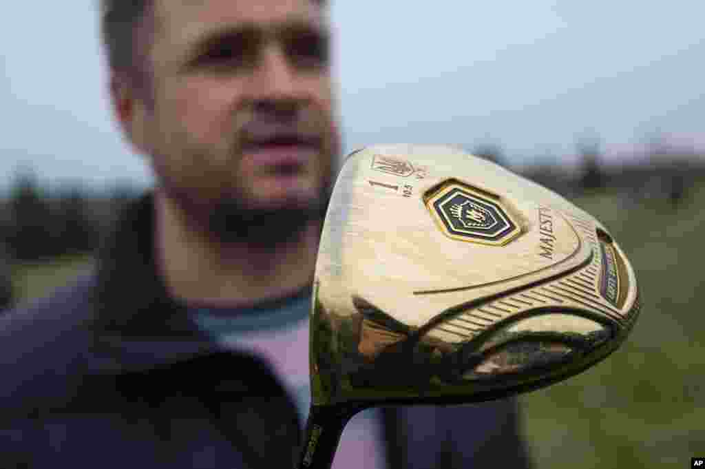 A man holds one of Viktor Yanukovych&#39;s golf clubs at the golf course on Yanukovych&#39;s countryside residence in Mezhyhirya, Feb, 22, 2014. 