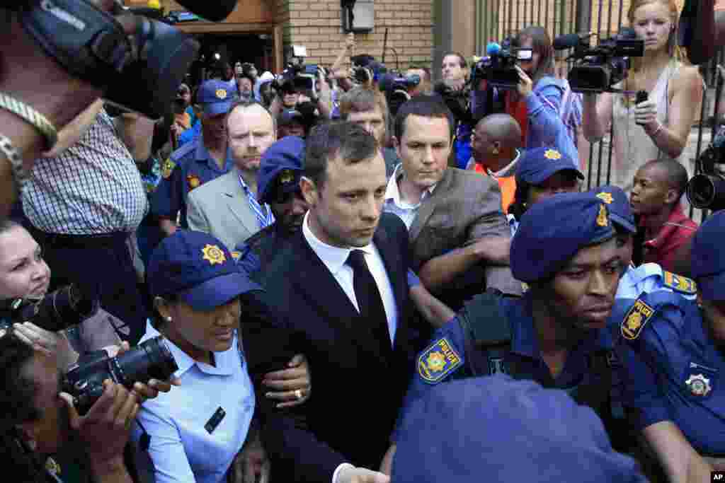 Escorted by police and security, Oscar Pistorius leaves the court in Pretoria, South Africa. Judge Thokozile Masipa ruled out a murder conviction for the double-amputee Olympian in the shooting death of his girlfriend, Reeva Steenkamp, but said he was negligent and convicted him of culpable homicide.