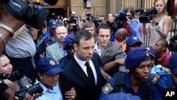 FILE: Escorted by police and security, Oscar Pistorius leaves the court in Pretoria, South Africa, Sept. 12, 2014. 