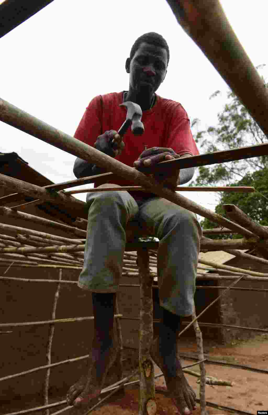 A man works on building a makeshift voting station near Gorongosa, central Mozambique, Nov. 19, 2013.