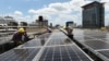 资料照片：中国浙江义乌市国际商贸城的屋顶，工人正在安装太阳能电池板（2017年7月17日)
