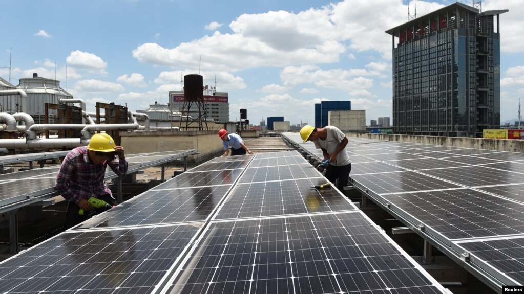 资料照片：中国浙江义乌市国际商贸城的屋顶，工人正在安装太阳能电池板（2017年7月17日)(photo:VOA)