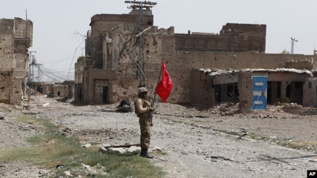 FILE - A Pakistani army soldier stands guard in Miranshah bazaar after driving out militants from Pakistan's tribal region of North Waziristan along the Afghanistan border, July 9, 2014.