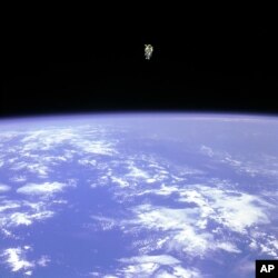 In this Feb. 12, 1984 photo made available by NASA, astronaut Bruce McCandless uses a nitrogen jet-propelled backpack, a Manned Manuevering Unit, outside the space shuttle Challenger.