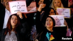 Protesters shout slogans and hold up signs denouncing the visit of Saudi Arabia's Crown Prince Mohammed bin Salman, in Tunis, Tunisia, Nov. 26, 2018.