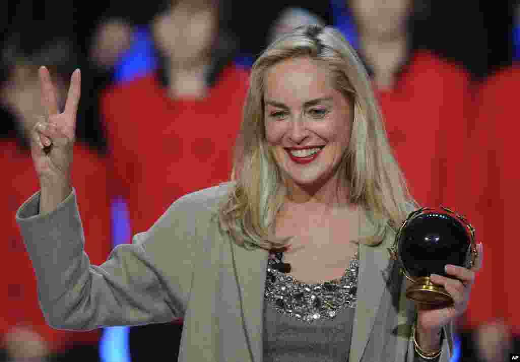 U.S. actress Sharon Stone shows a victory sign and holds the Nobel Peace laureates summit Peace Prize award during a ceremony, in Warsaw, Poland. Stone was awarded with the prize in recognition of her activities against HIV and AIDS. 