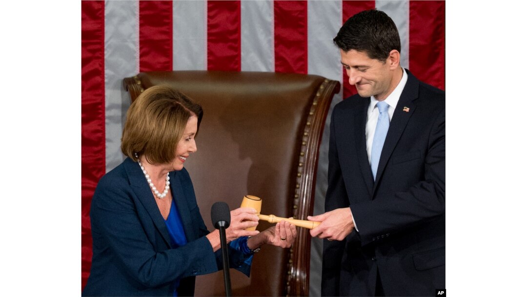 Newly elected House Speaker Paul Ryan of Wis., receives the Speaker's gavel from House Minority Leader Nancy Pelosi of Calif., in the House Chamber on Capitol Hill in Washington, Oct. 29, 2015.