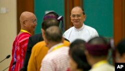 Myanmar President Thein Sein, rear right, shakes hands with leaders of armed ethnic groups during a meeting for the Nationwide Ceasefire Agreement (NCA) between representatives of the Myanmar government and leaders of armed ethnic groups in Naypyidaw, Mya