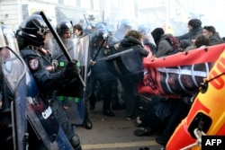 Police clash with demonstrators during an anti-fascist and anti-racist march to protest against a League (Lega) far-right party general election campaign rally in Milan, Italy, Feb. 24, 2018.