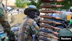 FILE - A South Sudanese soldier stands next to a machine gun mounted on a truck in Malakal town, northeast of Juba, South Sudan.