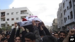 In this citizen journalism image made on a mobile phone and acquired Saturday April 23, 2011, by The AP, Syrian anti-government protesters carry the coffin of an activist who was killed on Friday during his funeral procession in Quaboun near Damascus, Syr