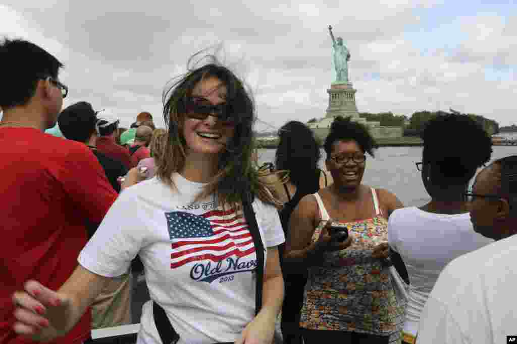 Visitors to the Statue of Liberty take photos as they arrive on the first tourist ferry to leave Manhattan, July 4, 2013 in New York.