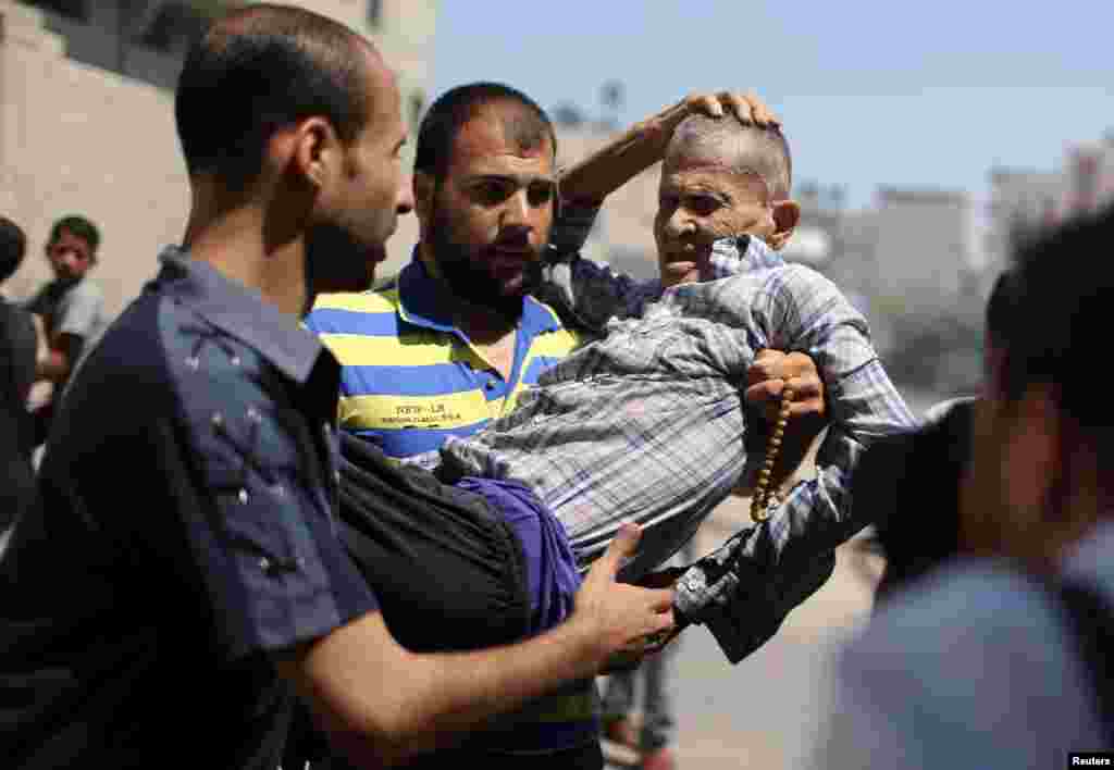 A wounded man is evacuated from the scene of an air strike in Gaza City, Aug. 21, 2014.