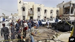 Iraqi security forces inspect the scene of a suicide car bomb attack in Basra, Iraq's second-largest city, 340 miles (550 kilometers) southeast of Baghdad, Iraq, June 13, 2011