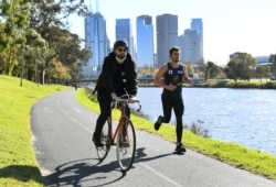 Orang-orang berolahraga di Melbourne, Australia di tengah perpanjangan lockdown akibat pandemi COVID-19, 2 Juni 2021. (Foto: William WEST/AFP)