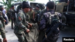 Philippine National Police (PNP) carry a body bag, containing a member of the Special Action Force, to a van in Mamasapano town, Maguindanao province, January 26, 2015.