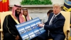 Tổng thống Donald Trump cho xem một tấm bảng minh họa những thương vụ vũ khí với Ả-rập Xê-út trong một cuộc hội kiến Thái tử Mohammed bin Salman trong Phòng Bầu dục của Nhà Trắng, ngày 20 tháng 3, 2018, ở Washington.