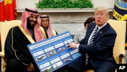 FILE - President Donald Trump shows a chart highlighting arms sales to Saudi Arabia during a meeting with Saudi Crown Prince Mohammed bin Salman in the Oval Office of the White House, March 20, 2018.