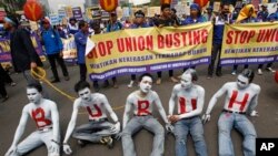 Para pekerja mencat wajah dan tubuhnya dalam aksi demonstrasi memperingati Hari Buruh Sedunia di Jakarta, Rabu (1/5). (AP/Achmad Ibrahim)
