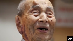 Yasutaro Koide, the 112-year-old living in the central Japanese city of Nagoya, smiles upon being formally recognized as the world's oldest man by the Guinness World Records at a nursing home in Nagoya, Aug. 21, 2015.