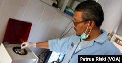 Andreas dari Ecoton meneliti feses manusia yang ditemukan ada mikroplastik (foto Petrus Riski-VOA).jpg