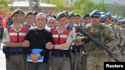 Akin Ozturk, a former Turkish Air Force commander who is accused of plotting and orchestrating last year's failed coup, is escorted by gendarmes as he arrives at the court in Ankara, Turkey, May 22, 2017. 