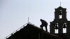 Radnik popravlja krov na crkvi Svete nedelje (Foto: AP/Darko Vojinović)