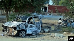 Cars, which were torched by an angry mob, are seen in front of a damaged police station in Mandani, an area of Charsadda district, Pakistan, Nov. 29, 2021.