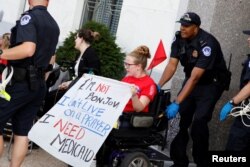 Capitol Police detain a demonstrator as the Senate Finance Committee holds a hearing on the latest Republican effort to repeal and replace the Affordable Care Act in Washington, Sept. 25, 2017.