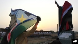 A woman carries a South Sudan flag as she arrives at the John Garang Mouselium for the Independence Day celebrations in the capital Juba July 9, 2011.