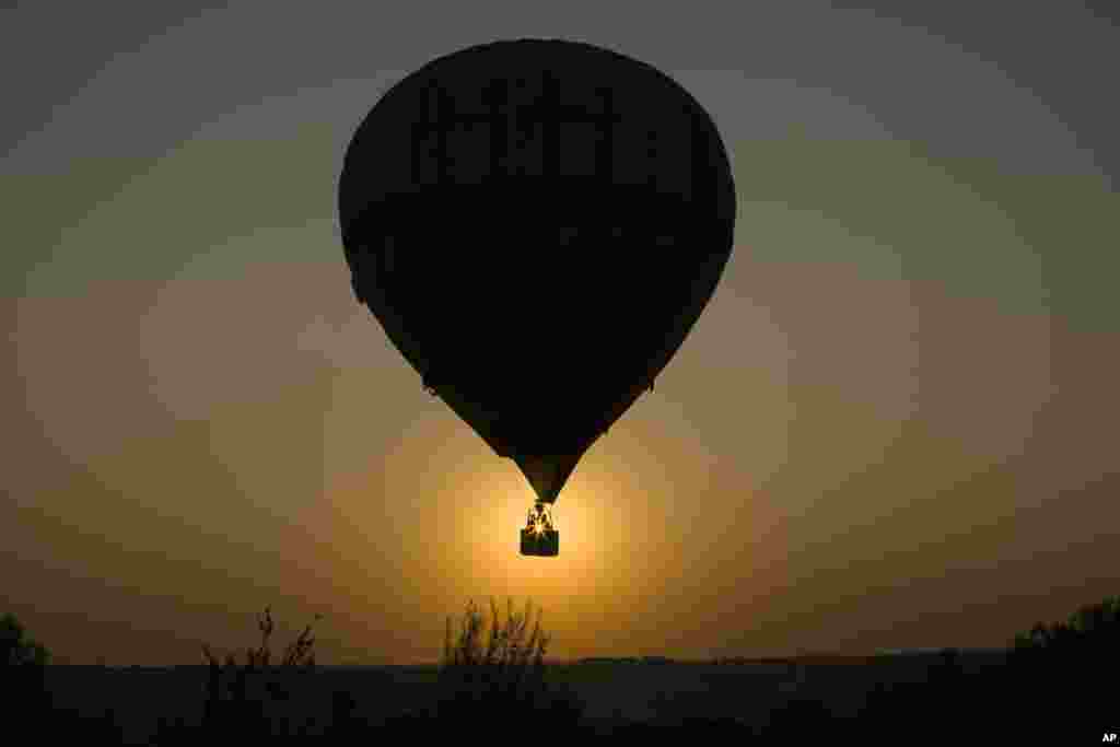 A couple enjoys a a hot-air balloon flight over the Peremilovo village, 65 km (40 miles) north of Moscow during the sunset, Aug. 20, 2017.