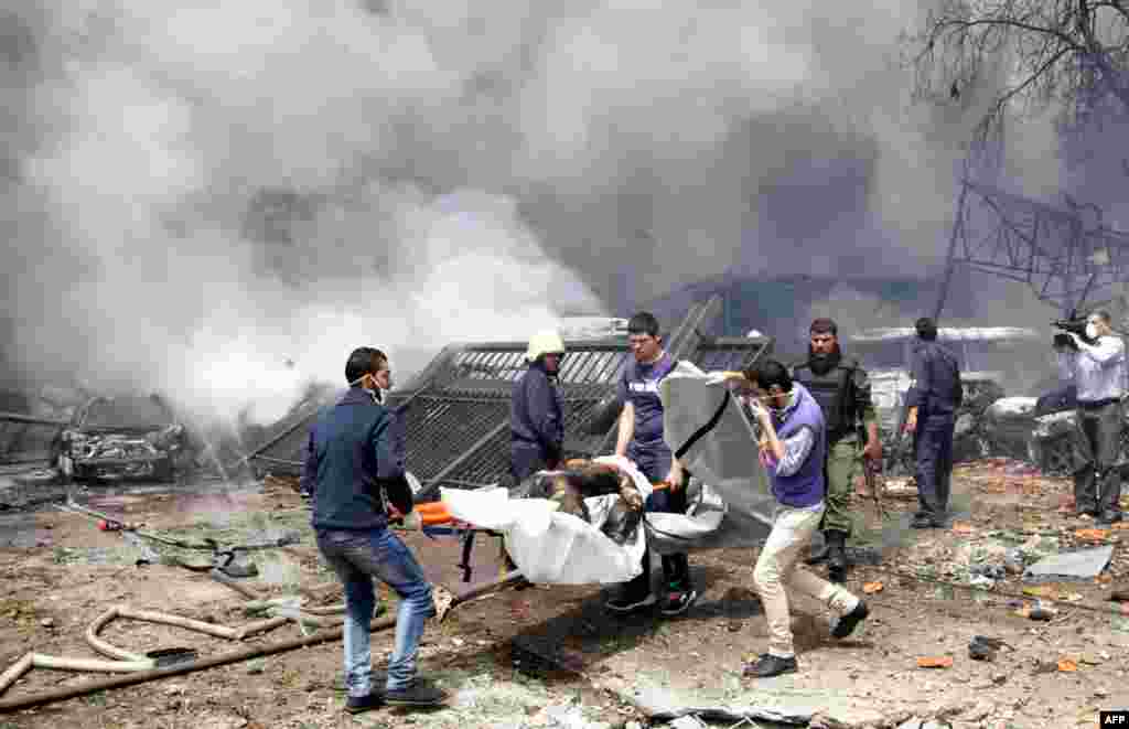 Rescue teams recover bodies from the scene of a car bomb explosion which rocked central Damascus on April 8, 2013.