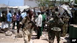 Police and soldiers gather at the site of a suicide blast near the compound of Somali President Sharif Sheikh Ahmed, Mogadishu, March 14, 2012.