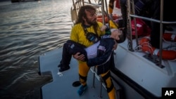Un secouriste transporte un jeune migrant victime du naufrage d'un bateau lors d'une traversée la mer Egée, venant de la Turquie pour l’île grecque de Lesbos, 28 octobre 2015. (AP Photo/Santi Palacios)