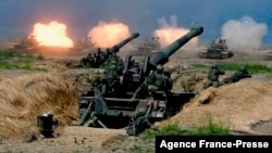 FILE - US-made CM-11 tanks (in background) are fired in front of two 8-inch self-propelled artillery guns during the 35th 'Han Kuang' (Han Glory) military drill in southern Taiwan's Pingtung county on May 30, 2019. 