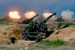 FILE - U.S.-made CM-11 tanks (in background) are fired in front of two 8-inch self-propelled artillery guns during the 35th Han Kuang (Han Glory) military drill in southern Taiwan's Pingtung county, May 30, 2019.