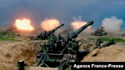 FILE - US-made CM-11 tanks (in background) are fired in front of two 8-inch self-propelled artillery guns during the 35th 'Han Kuang' (Han Glory) military drill in southern Taiwan's Pingtung county on May 30, 2019.